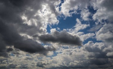 Mavi gökyüzüne karşı kara kümülüs bulutları.