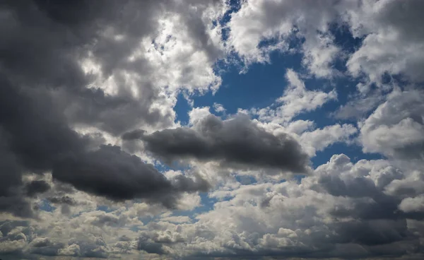 Mavi gökyüzüne karşı kara kümülüs bulutları.
