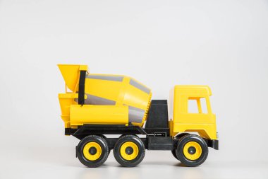 Plastik araba. Oyuncak modeli beyaz arka planda izole edilmiş. Bina betonu taşımak için sarı kamyon.