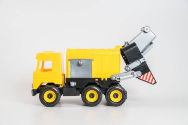 Plastik araba. Oyuncak modeli beyaz arka planda izole edilmiş. Çöp taşımak için sarı kamyon.
