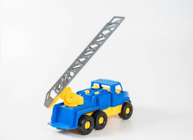 Plastik araba. Oyuncak modeli beyaz arka planda izole edilmiş. Yangın çıkışlı sarı-mavi kamyonet..