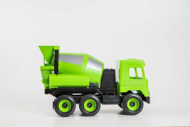 Plastik araba. Oyuncak modeli beyaz arka planda izole edilmiş. Beton taşımak için yeşil kamyon.