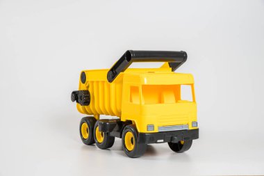 Plastik araba. Oyuncak modeli beyaz arka planda izole edilmiş. Sarı kamyon..