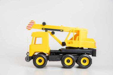 Plastik araba. Oyuncak modeli beyaz arka planda izole edilmiş. Sarı kamyon monte edilmiş vinç.
