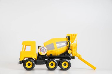 Plastik araba. Oyuncak modeli beyaz arka planda izole edilmiş. Bina betonu taşımak için sarı kamyon.