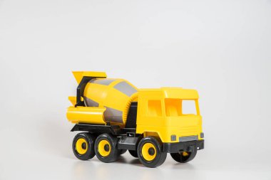 Plastik araba. Oyuncak modeli beyaz arka planda izole edilmiş. Bina betonu taşımak için sarı kamyon.