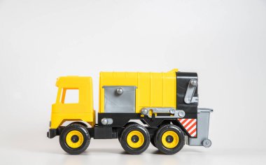 Plastik araba. Oyuncak modeli beyaz arka planda izole edilmiş. Çöp taşımak için sarı kamyon.