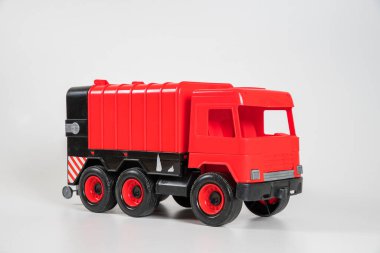 Plastik araba. Oyuncak modeli beyaz arka planda izole edilmiş. Çöp taşımak için kırmızı kamyon..