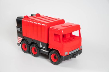 Plastik araba. Oyuncak modeli beyaz arka planda izole edilmiş. Çöp taşımak için kırmızı kamyon..