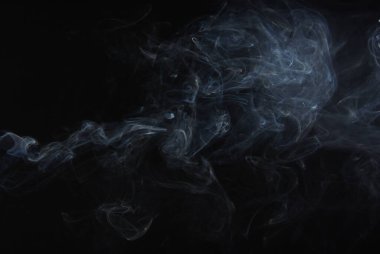 Siyah arkaplandaki duman zerreleri soyut.