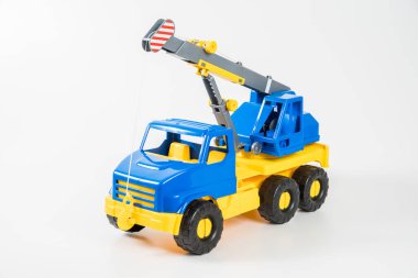 Plastik araba. Oyuncak modeli beyaz arka planda izole edilmiş. Yükünü kaldırmak için ok taşıyan sarı-mavi bir vinç..