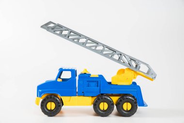 Plastik araba. Oyuncak modeli beyaz arka planda izole edilmiş. Yangın çıkışlı sarı-mavi kamyonet..