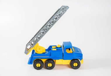 Plastik araba. Oyuncak modeli beyaz arka planda izole edilmiş. Yangın çıkışlı sarı-mavi kamyonet..