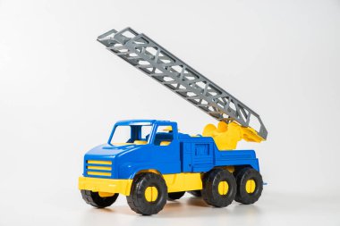 Plastik araba. Oyuncak modeli beyaz arka planda izole edilmiş. Yangın çıkışlı sarı-mavi kamyonet..