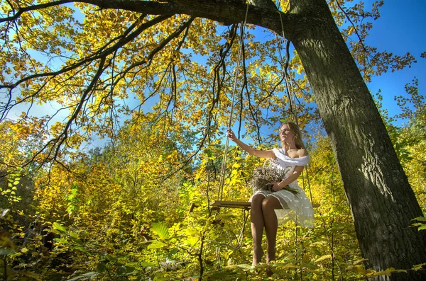 Menina Está Balançando Balanço Floresta Outono Contra Fundo Folhagem Amarelo — Fotografia de Stock