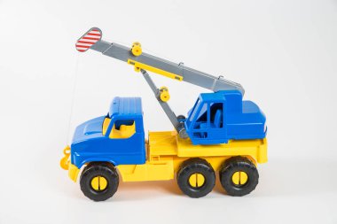 Plastik araba. Oyuncak modeli beyaz arka planda izole edilmiş. Yükünü kaldırmak için ok taşıyan sarı-mavi bir vinç..