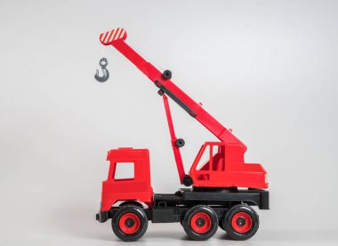 Beyaz arka planda çok renkli plastik çocuk arabaları. Kırmızı kamyon vinci.