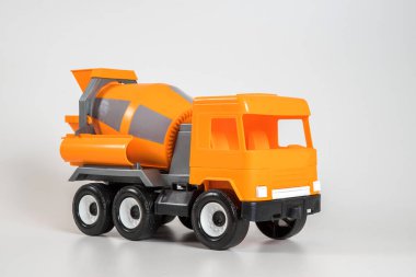 Beyaz arka planda çok renkli plastik çocuk arabaları. Turuncu beton kamyon.