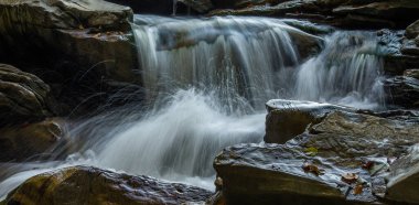 Taşlar arasında bir dağ nehrinin hızlı akışı. Uzun pozlama. Hareket bulanıklığı. Seçici odak.