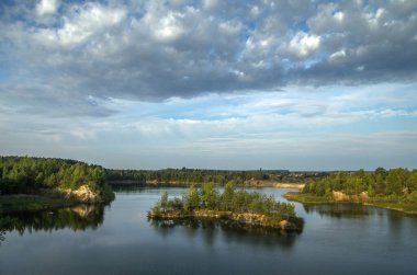 Eski bir granit ocağı ve kumlu kayalık bir kıyısı ve ağaçlarla kaplı adaları olan bir göl..