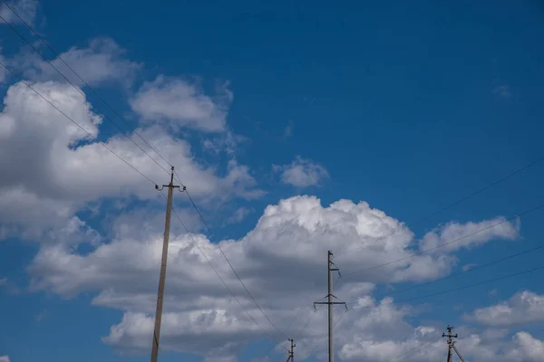 Электрические Столбы Против Летнего Голубого Неба Кучевыми Облаками — стоковое фото