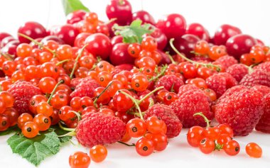 Beyaz arka planda çeşitli meyveler. Kiraz, ahududu, frenk üzümü.