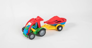 Plastik oyuncak, çok renkli arabalar beyaz arka planda izole edilmiş. Karavanda motorlu tekne olan bir araba..