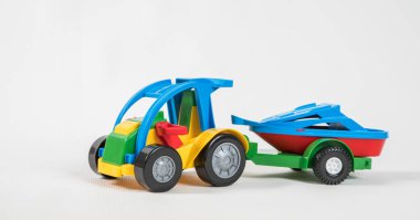 Plastik oyuncak, çok renkli arabalar beyaz arka planda izole edilmiş. Karavanda motorlu tekne olan bir araba..
