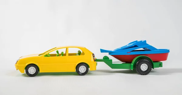Plastové hračky mnohobarevné automobily izolované na bílém pozadí. Auto s motorovým člunem na přívěsu. — Stock fotografie