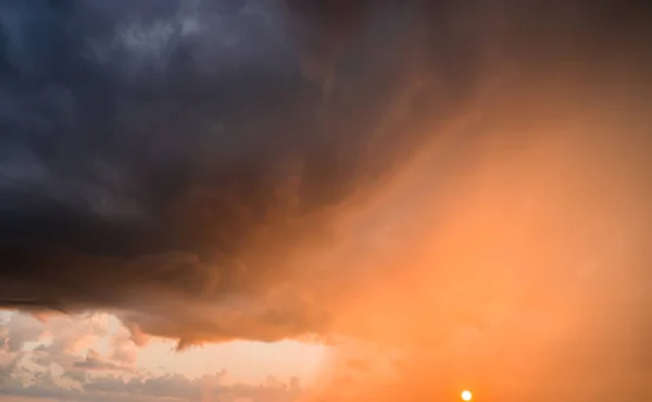 Puesta de sol con lluvia y nubes oscuras. Sol, sol, rayos. — Foto de Stock