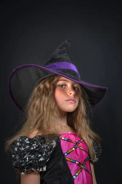 Egy boszorkánynak öltözött lány és egy széles karimájú kalap Halloweenkor.. — Stock Fotó