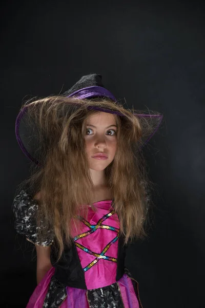 Cadı gibi giyinmiş bir kız ve Cadılar Bayramı için geniş kenarlı bir şapka.. — Stok fotoğraf