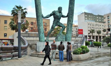 İnsanlar şehirde Herkül heykeli dikkatle gözlemlemek