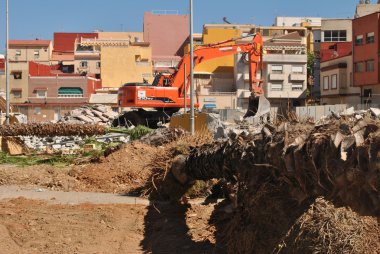 Bulldocer çalışma palmiye ağaçları ve Binalar ile çevrili bir İspanyol şehri çalışır