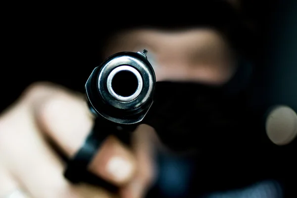 Burglar or terrorist in black mask shooting with gun — Stock Photo, Image