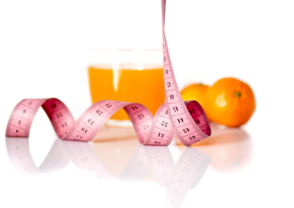 Frutas y cinta métrica sobre un fondo blanco para simbolizar una dieta saludable — Foto de Stock