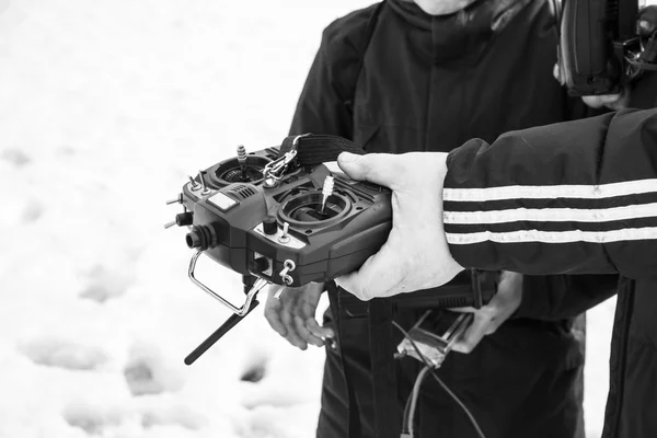 Quadrocopter pilóta nélküli légi járművek, a hó a kezükben távirányító. — Stock Fotó