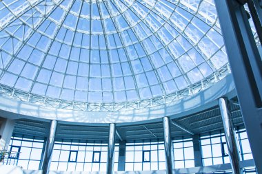 Özgün tasarım cam ve metal bir gökdelen, mavi gökyüzü bir kubbe şeklinde 