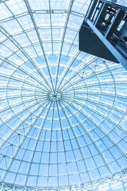 Özgün tasarım cam ve metal bir gökdelen, mavi gökyüzü bir kubbe şeklinde 