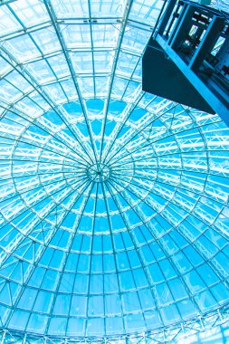 Özgün tasarım cam ve metal bir gökdelen, mavi gökyüzü bir kubbe şeklinde 