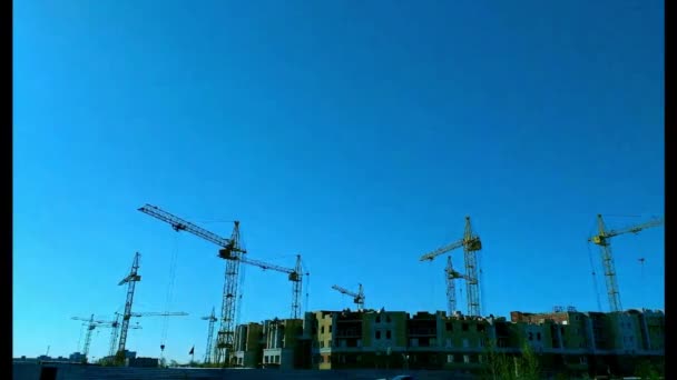 Housing in clear weather a lot of cranes working on a construction site — Stock Video