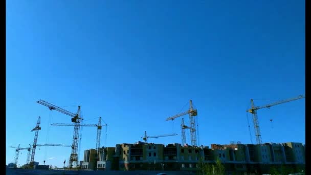 Housing in clear weather a lot of cranes working on a construction site — Stock Video