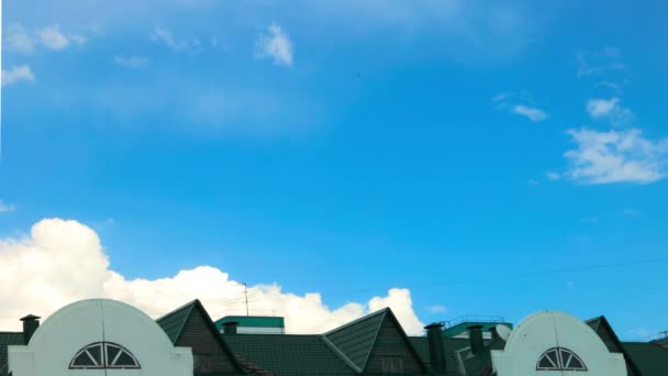 La formación de nubes en el cielo en un día claro sobre un fondo de techo verde de una casa. lapso de tiempo — Vídeos de Stock