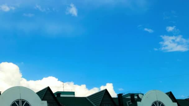 Формирование облаков в небе в ясный день на фоне зеленой крыши дома. timelapse — стоковое видео