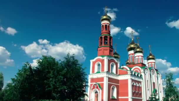 Igreja incrivelmente bonita de tijolo vermelho com cúpulas de ouro contra o céu azul claro. período de tempo — Vídeo de Stock