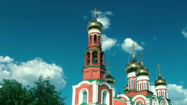 Verbluffend mooie kerk van rode baksteen met gouden koepels tegen de heldere blauwe hemel. timelapse — Stockvideo