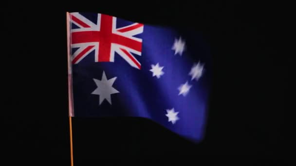 Національний прапор Австралії на вітрі, на чорному тлі. — стокове відео