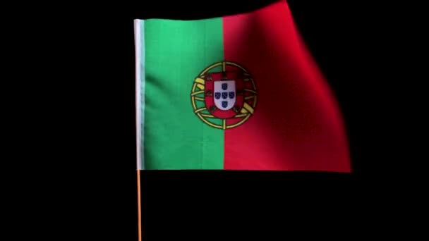 Portugália nemzeti zászlaja a szélben, fekete háttérrel