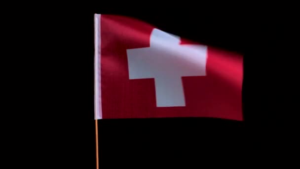 Nationell flagga i Schweiz flyger i vinden på en svart bakgrund — Stockvideo