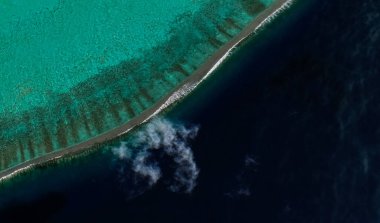 Bora Bora tatil beldesi adasının kıyı manzarası turkuaz su ve kumlu plajlardan kuş bakışı manzaralı.